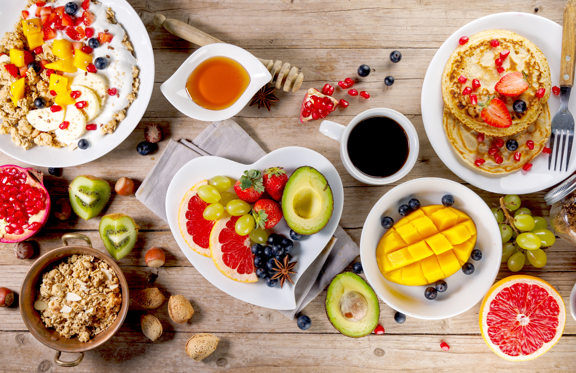 Image 1 : Un petit déjeuner équilibré composé de fruits frais, yaourt, granola et pancakes, accompagné d’un café noir. Les bienfaits d’un bon petit déjeuner résident dans son apport en énergie et en nutriments essentiels pour bien commencer la journée.