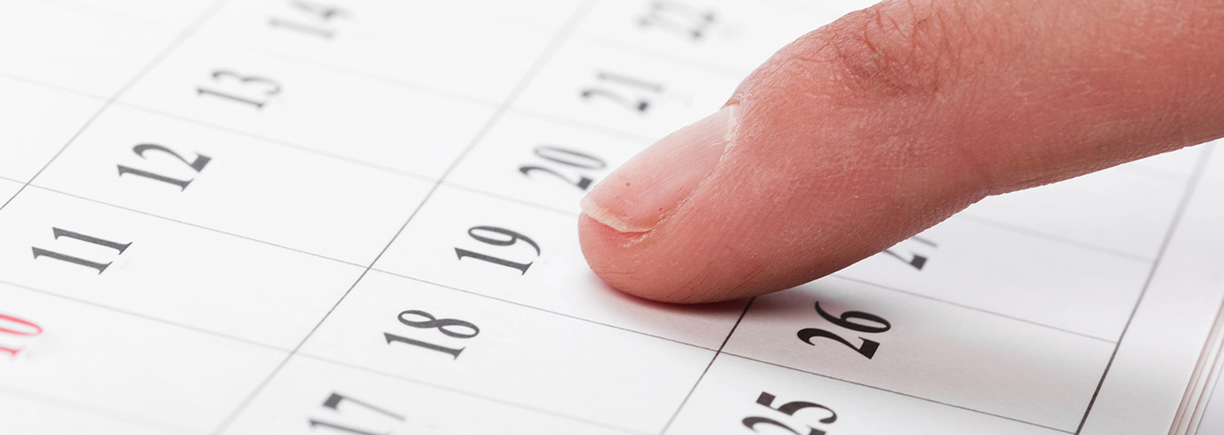 Doigt pointant une date de semaine sur un calendrier pour planifier un brunch chez allo mon coco