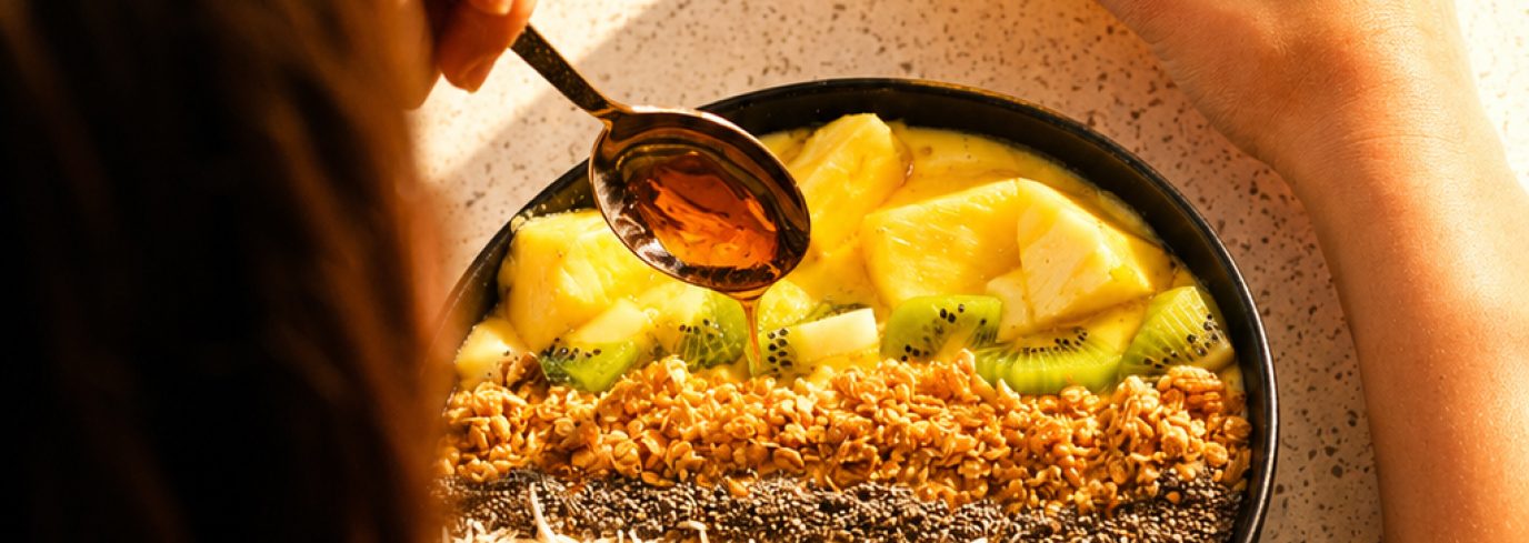 Bol smoothie aux fruits, granola, chia et noix de coco avec un filet de sirop, pour un brunch équilibré riche en fibres et fraîcheur