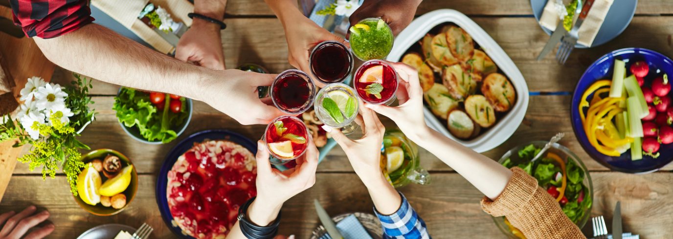Un groupe d'amis trinquant avec des cocktails colorés autour d'un brunch gourmand composé de salades, gratins et desserts. Découvrez les meilleures boissons pour accompagner votre brunch et sublimer vos moments conviviaux.